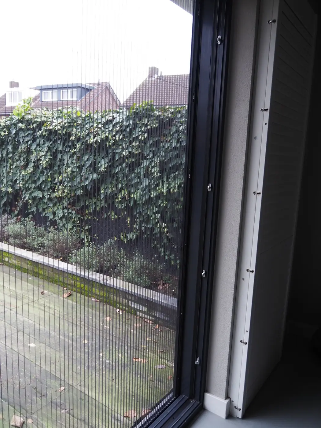Plissé hordeur half open bij een tuindeur
