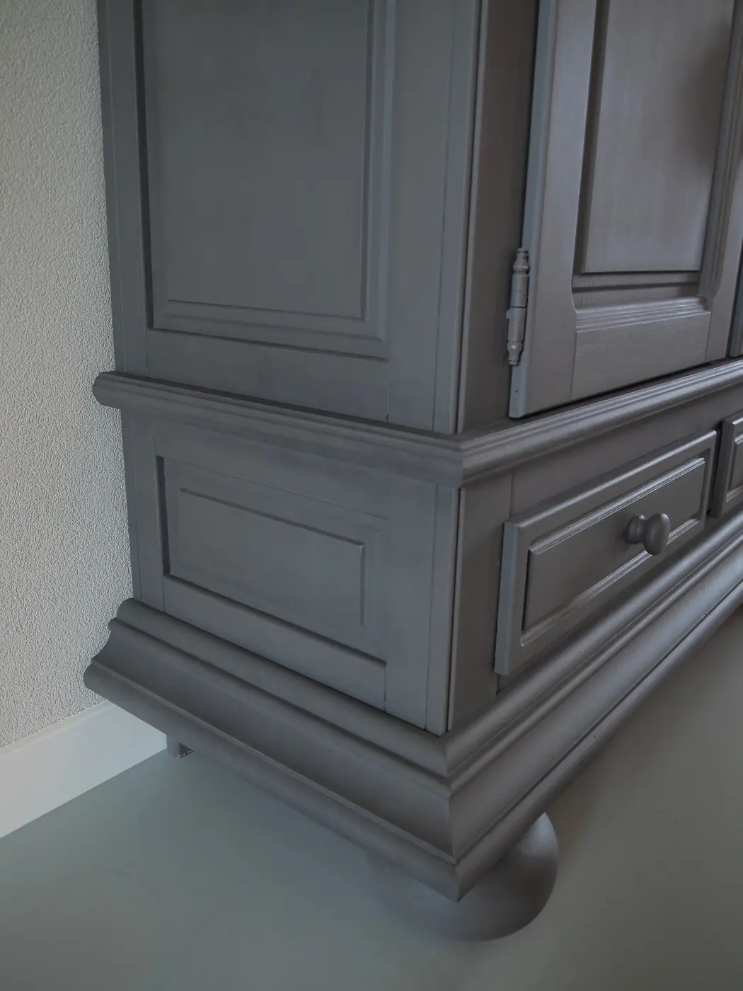Detail van het lijstwerk van een in krijtverf geschilderde linnenkast