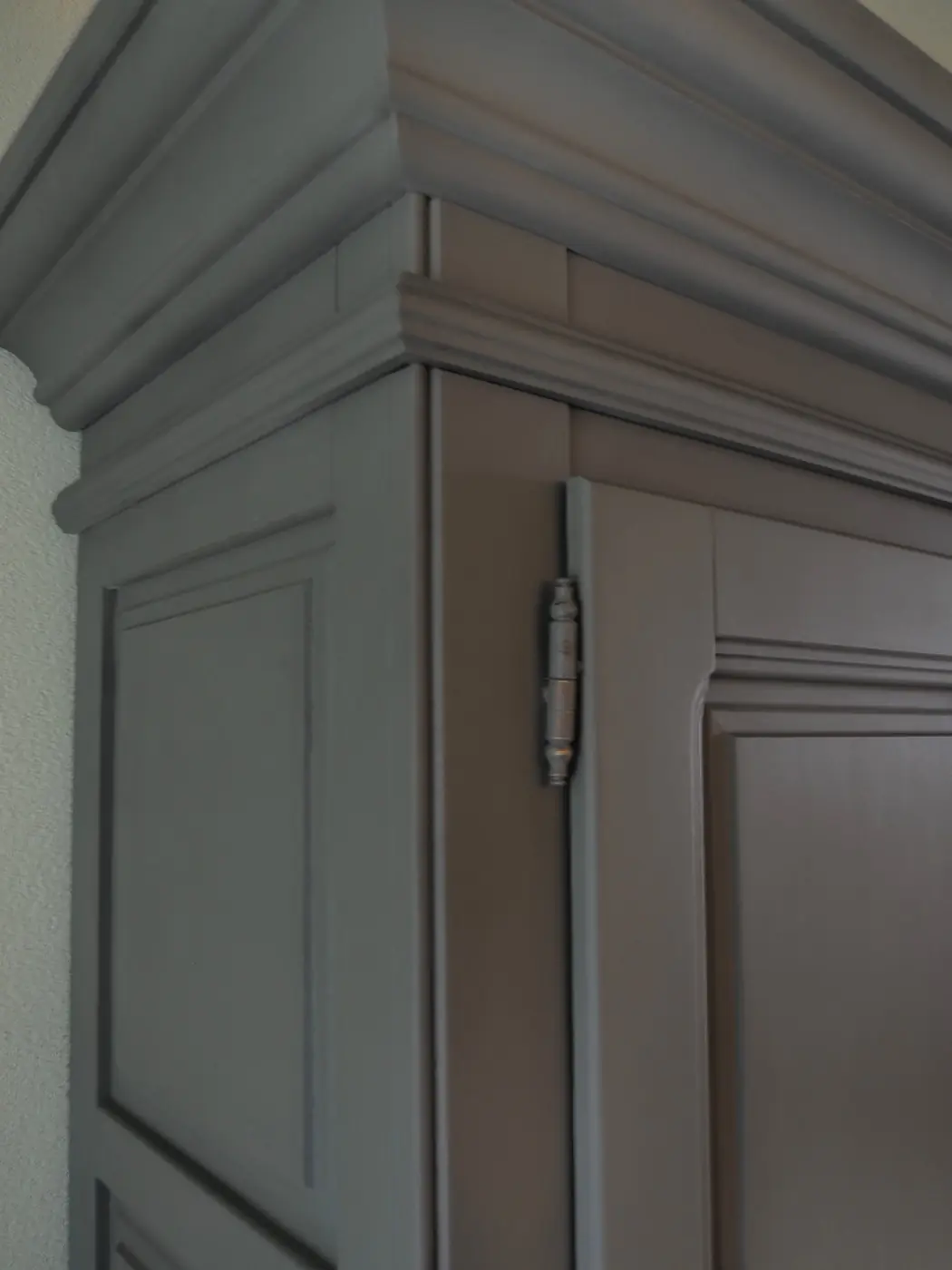 Detail van de kroonlijst van een antracietgrijs geschilderde kast