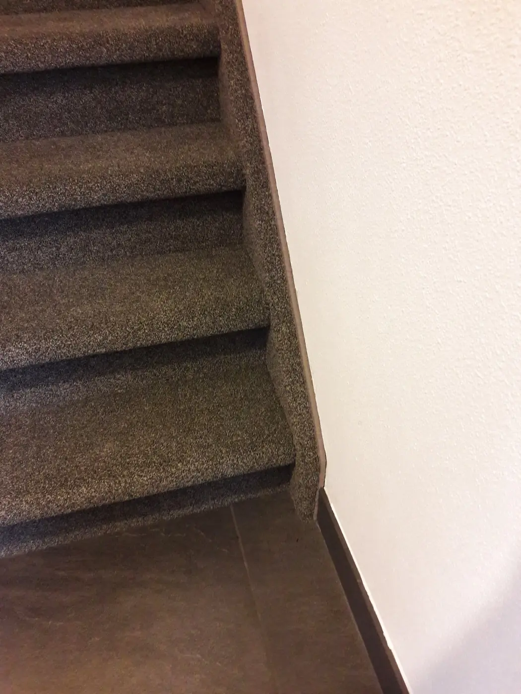 Detail van tapijt strak om de neus van de traptreden