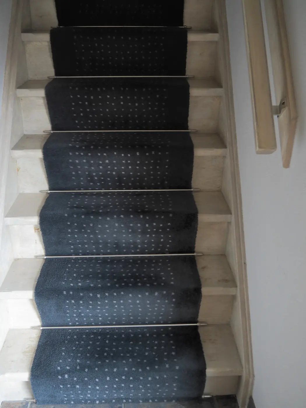 Antracietkleurige traploper met dessin op een witte trap