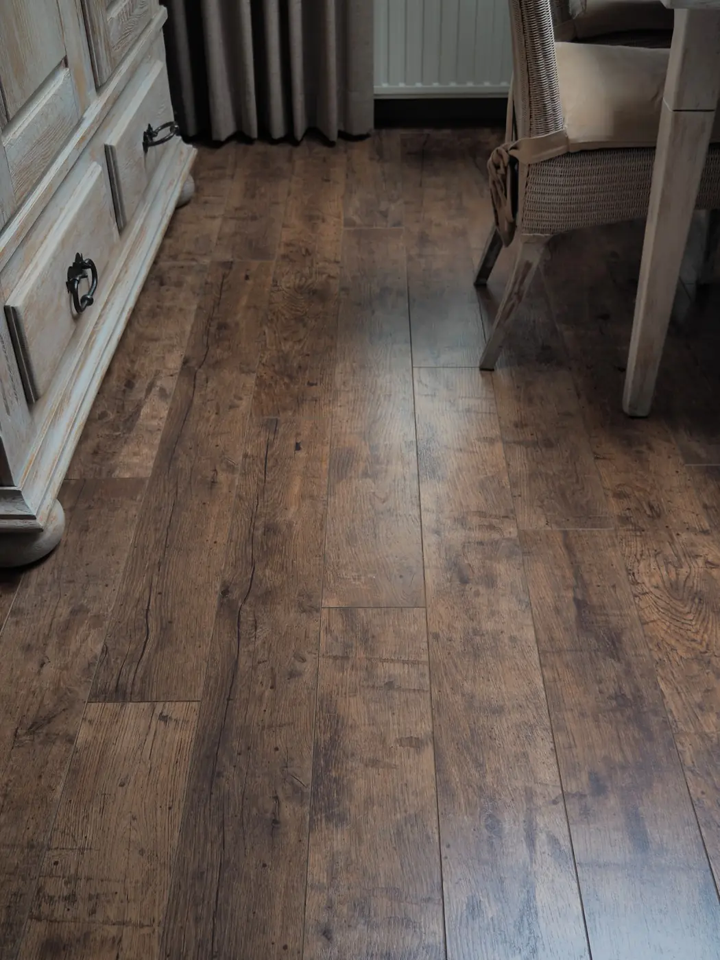 Houtlook vloer in een woonkamer, met vergrijsde kast en stoel